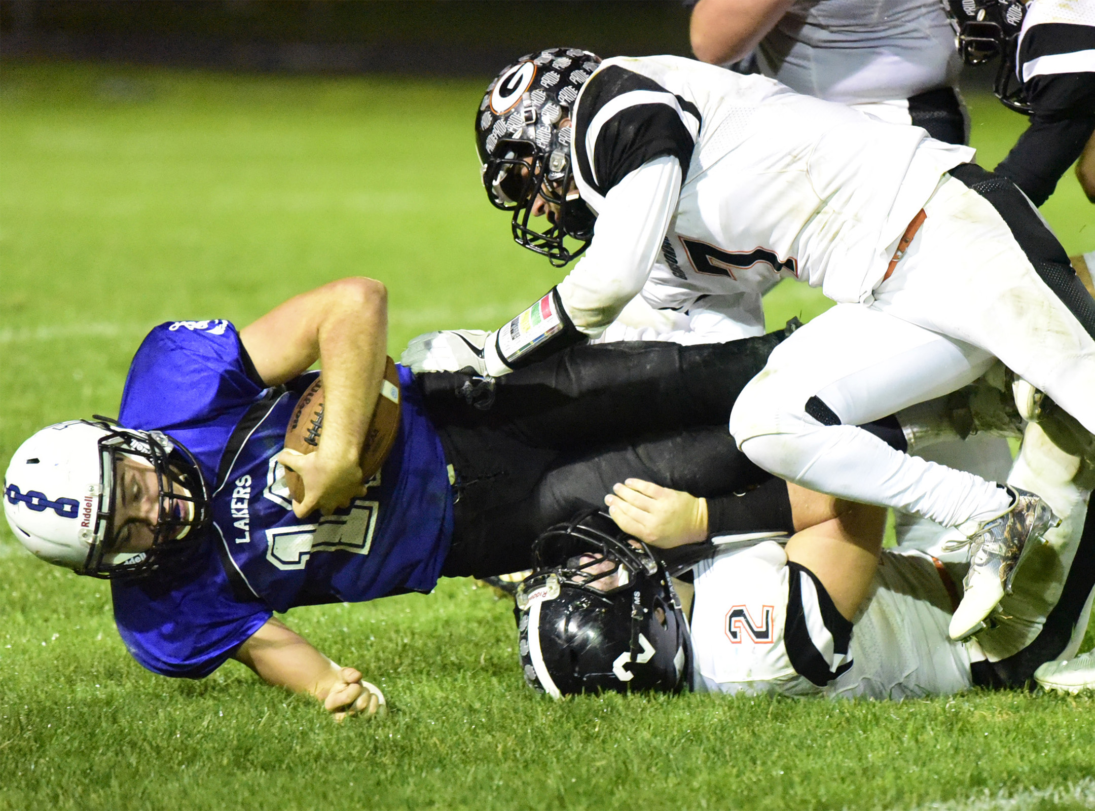 Danbury's Justin Tibbels is brought down by Gibsonburg's Isaak Arriaga, top, and Madison Jaso.