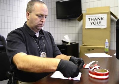 Detective Jason Kiddey of the Fremont Police Department with seized evidence of needles and suspected recovered heroin sized by the Fremont Police Department.