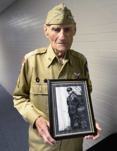 Jim McGrady holds a picture of himself from 1938, when he served in the infantry from 1936 to 1939.